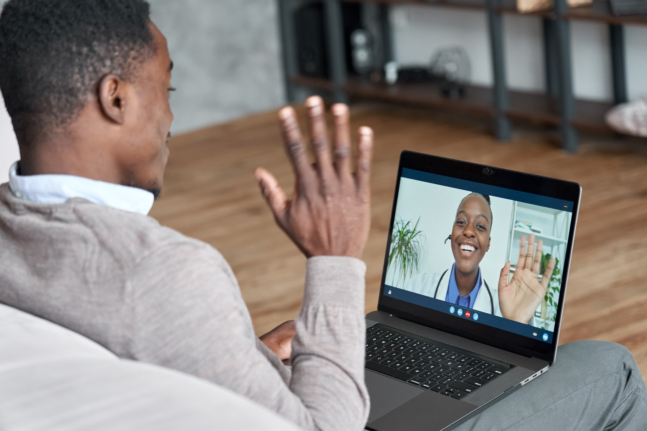 Male black patient talking on conference video call to female african doctor. Virtual therapist consulting young man during online appointment on laptop at home. Telemedicine chat, telehealth meeting